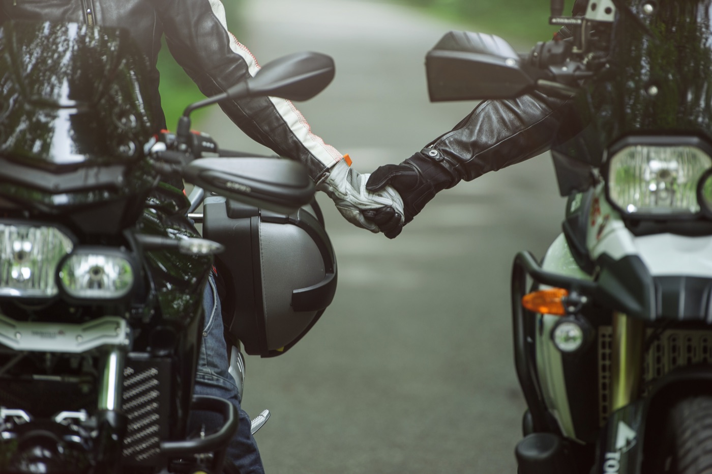 Casal de mãos dadas sobre a motocicleta